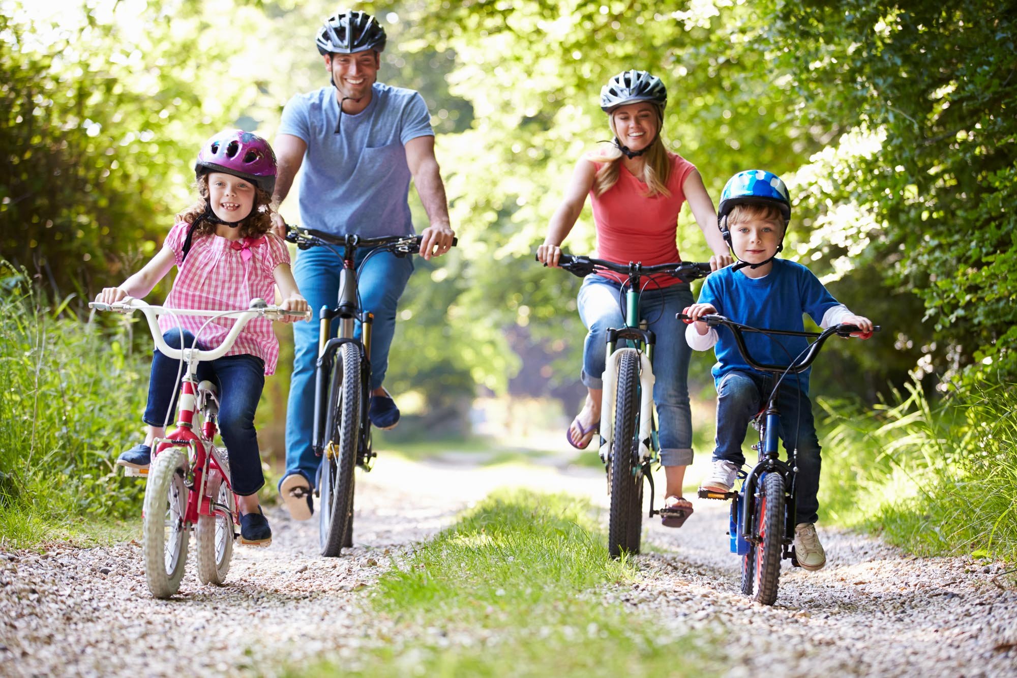Famille en balade à vélo, chacun portant un casque