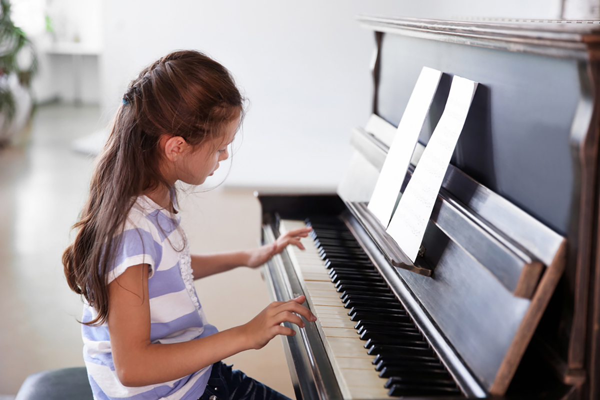 a little girl playing the piano