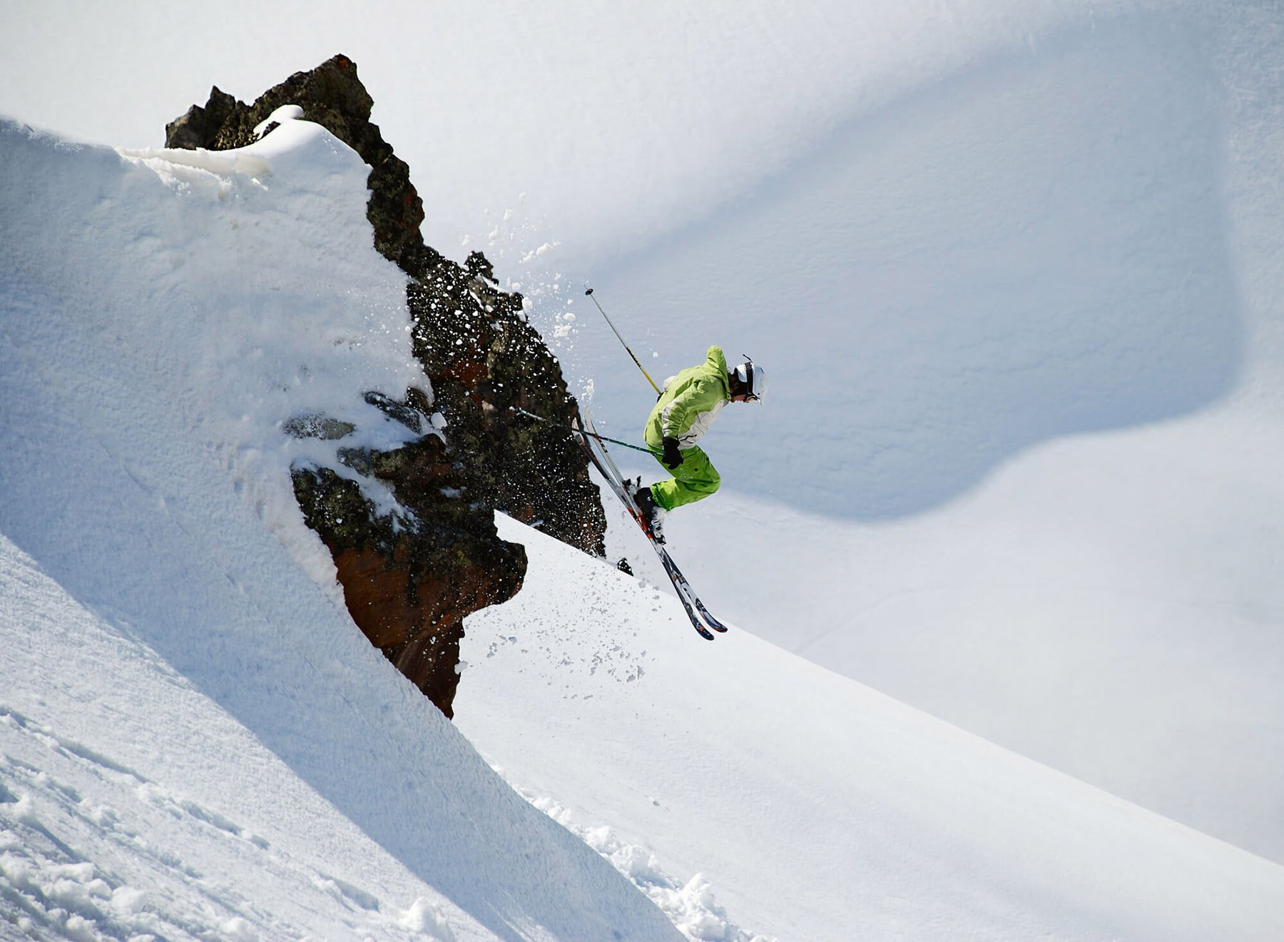 Ein Skifahrer springt von einem Felsen