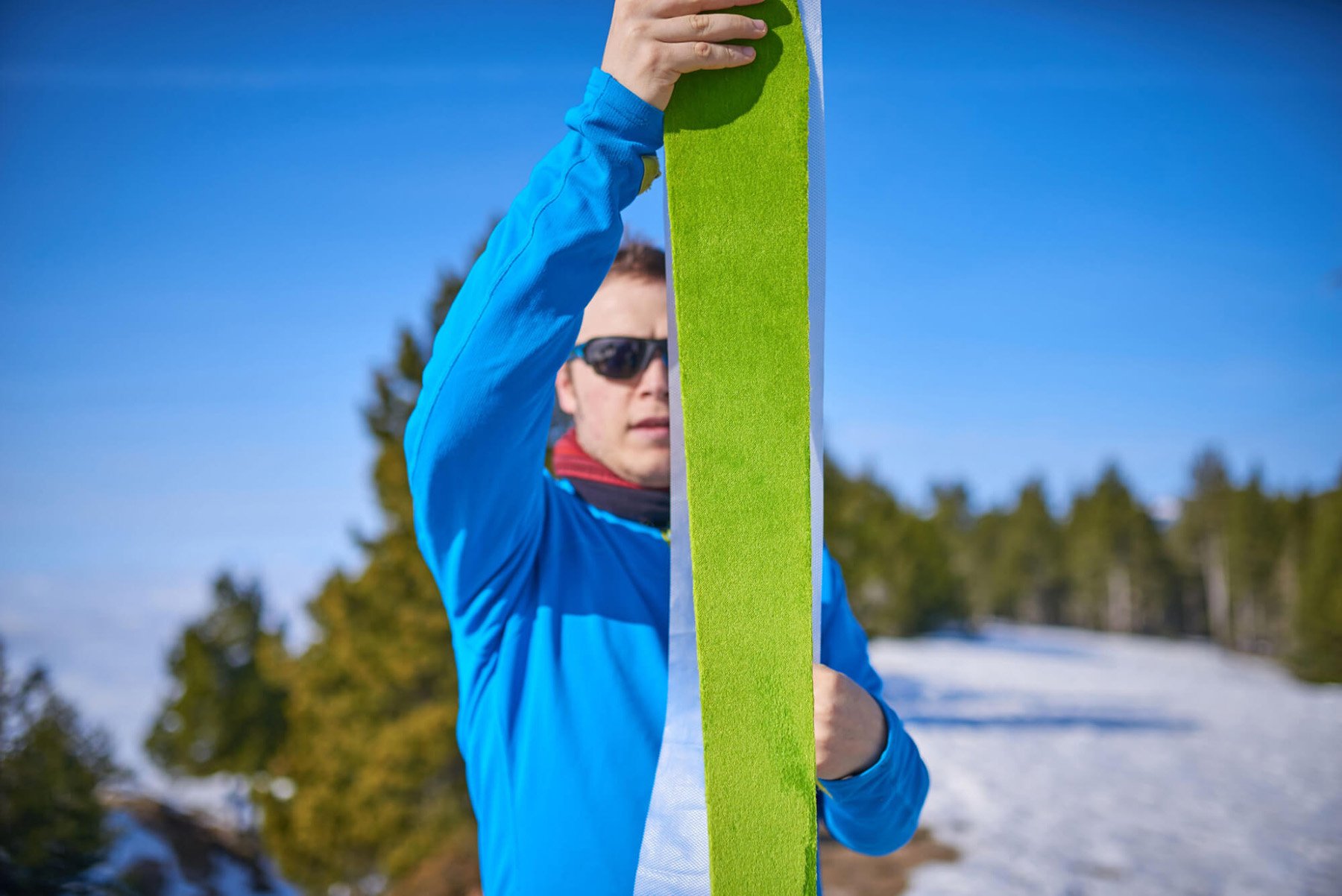 Ein Mann klebt das Skifell auf das Trennnetz