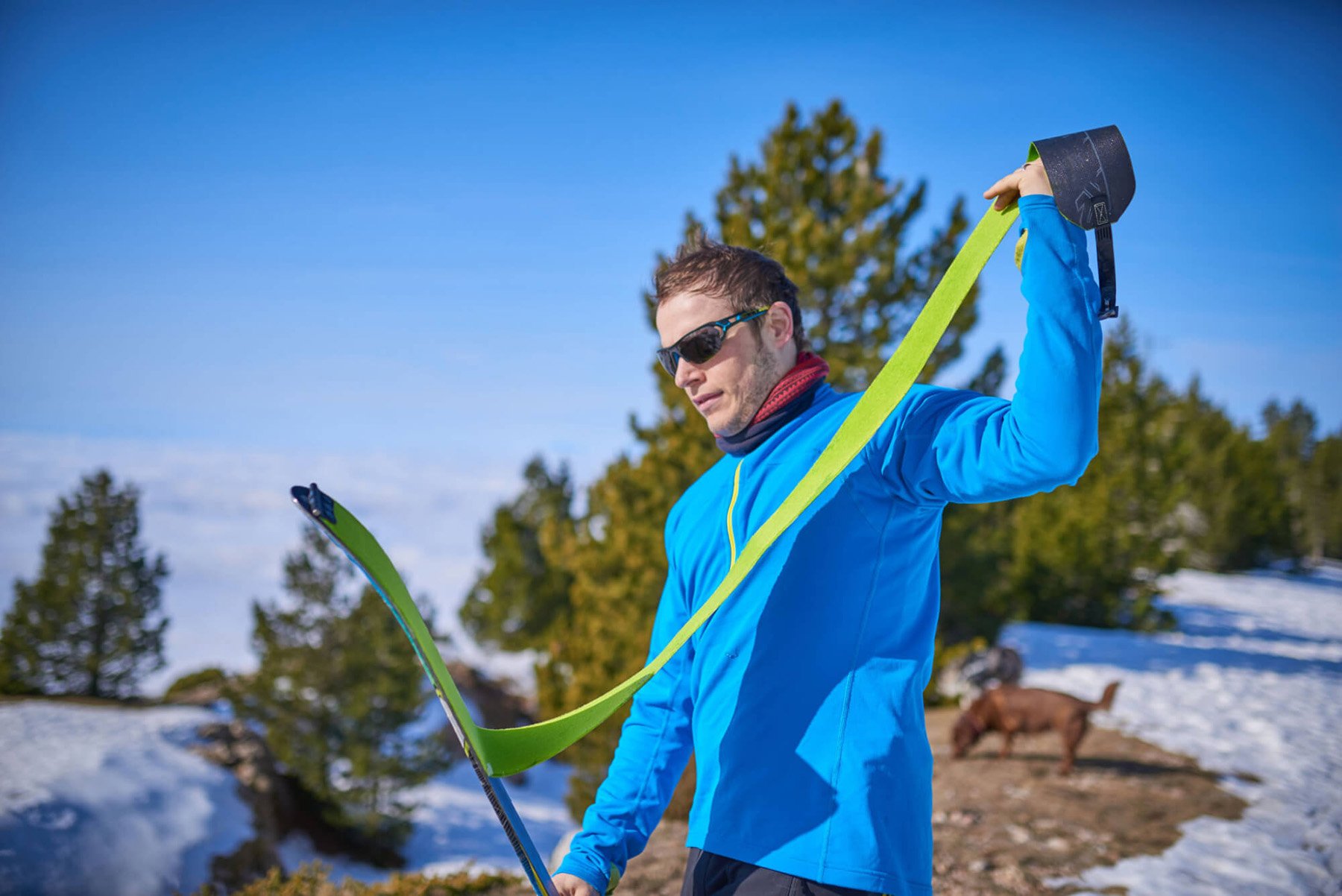 Muž nalepuje skialpové pásy na lyže