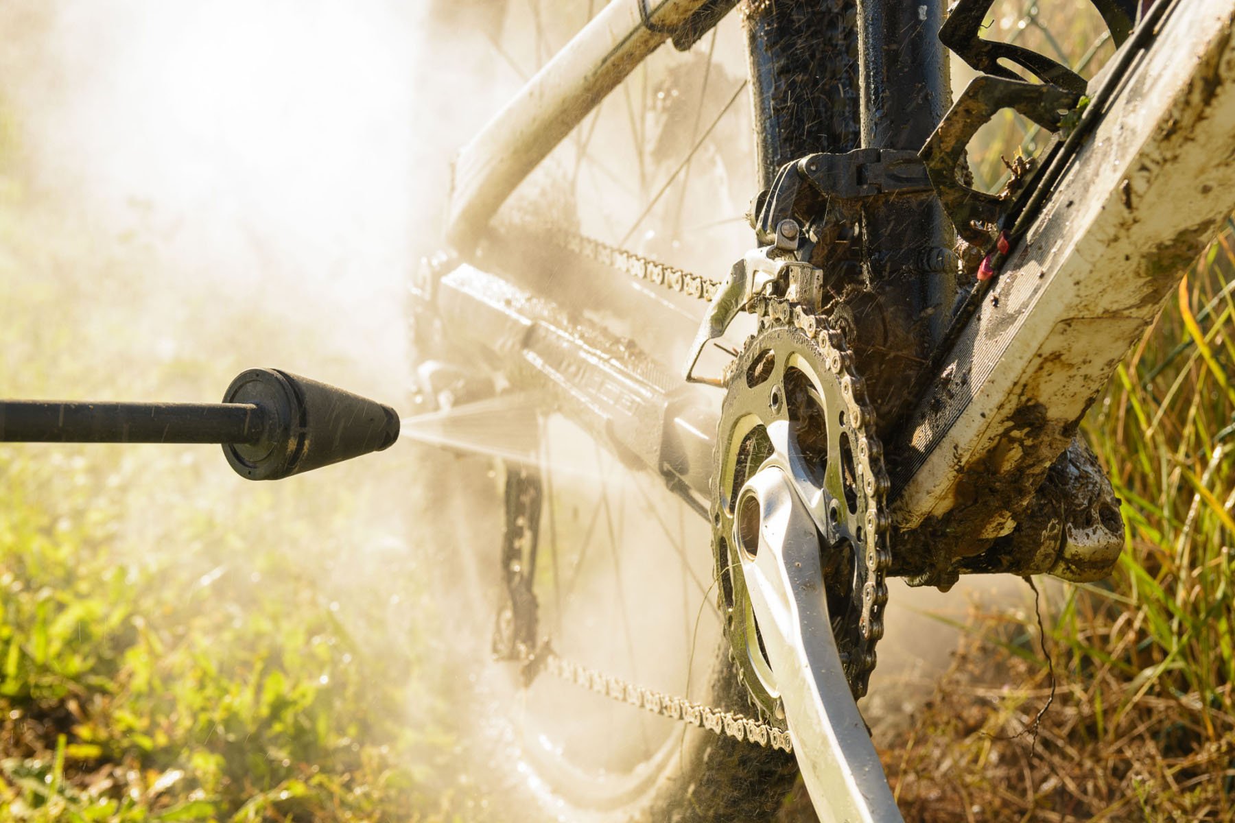 Cleaning a muddy mountain bike with spraying water