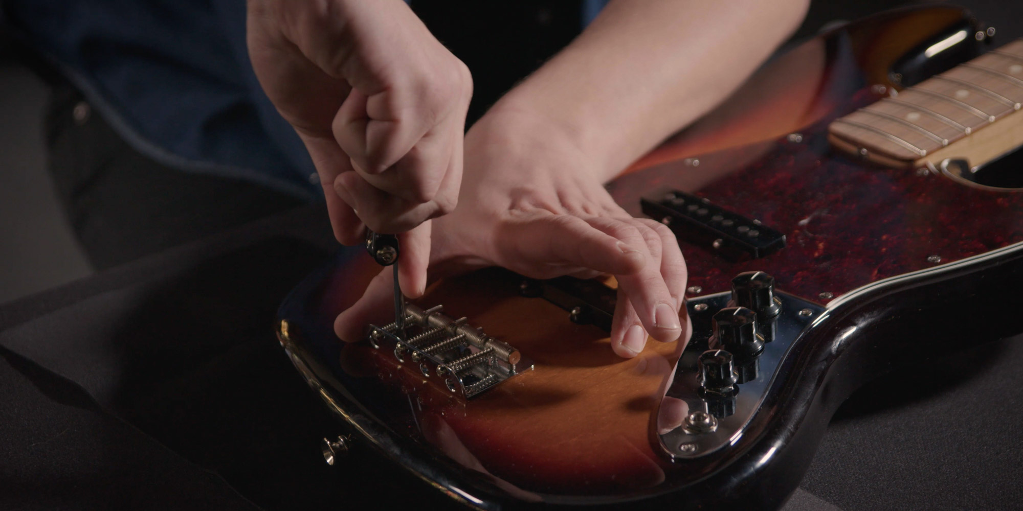Festziehen der Schrauben am Steg der Bassgitarre