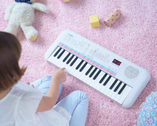 ein Mädchen spielt das Kinder-Keyboard Yamaha PSS-E30