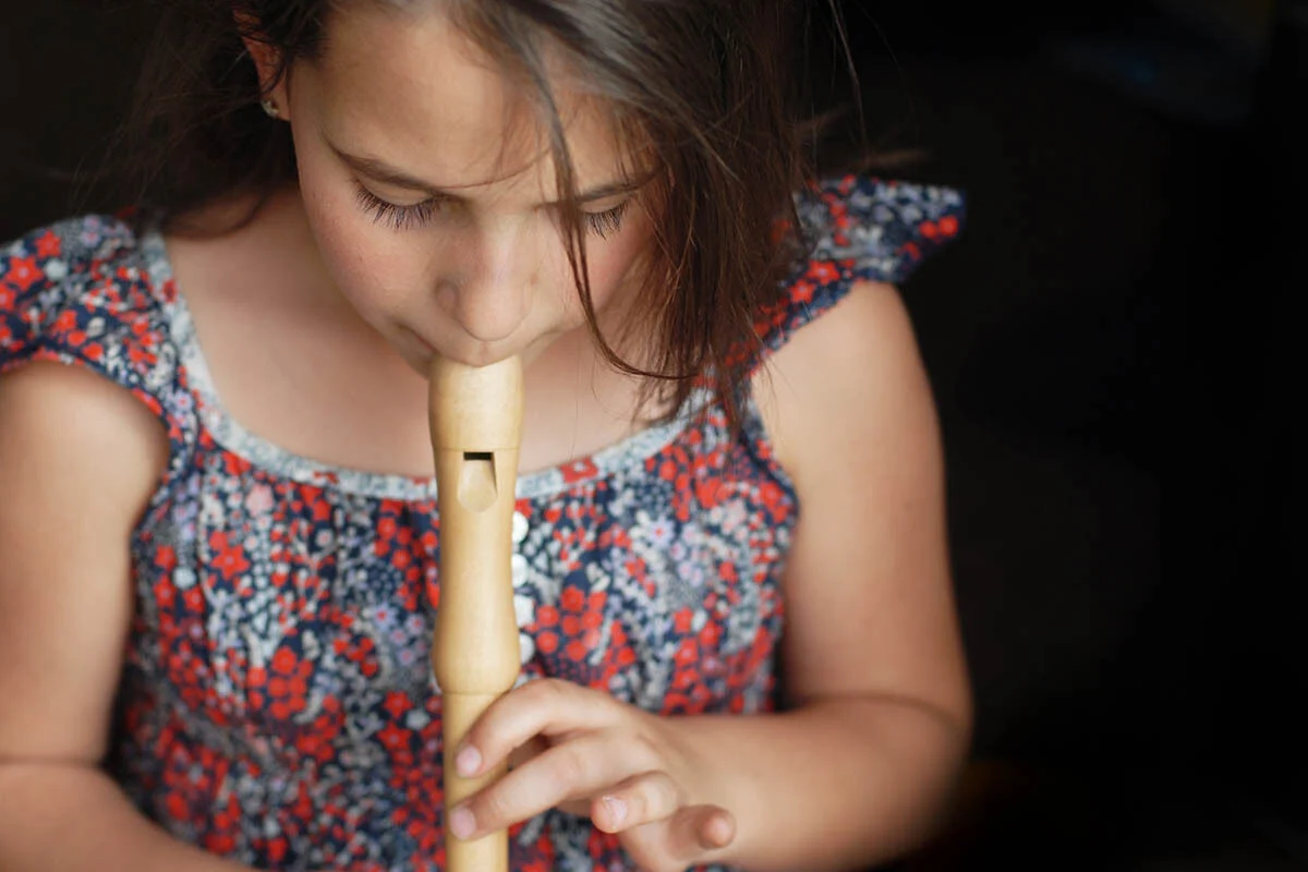 little girl playing the recorder
